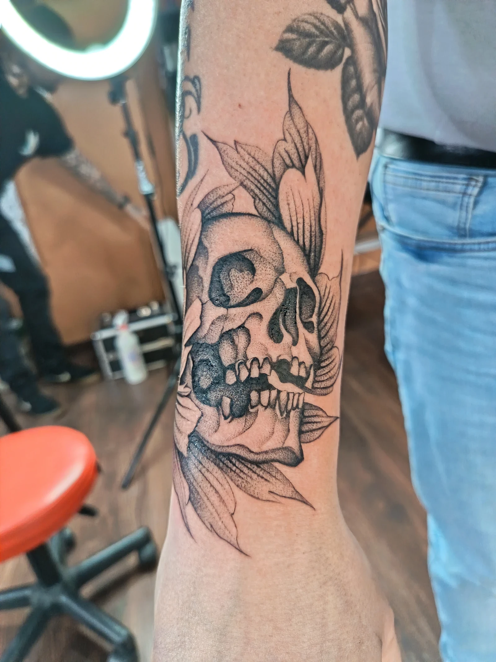 Braccio con tatuaggio noir di una teschia circondata da foglie, eseguito sul polso. locale Sailors Tattoo, Milano.